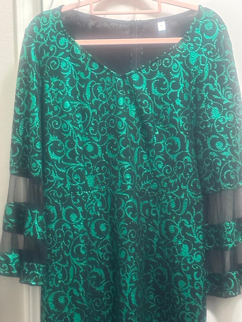 Close-up of candy apple green glitter holiday dress showing black sheer bell sleeve detail